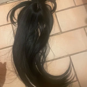 Svart löshår med clips - Säljer ett svart löshår med clips för enkel applicering. Perfekt för att snabbt få längre och fylligare hår. Clipsen är diskreta och håller löshåret säkert på plats.