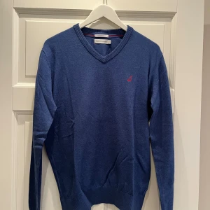 Blå kashmirblandad tröja från Peak Performance - Säljer en stilren blå tröja från Peak Performance i kashmirblandning. Tröjan har en v-ringad hals och ett diskret broderat märke på bröstet. Perfekt för en avslappnad men ändå elegant look. Passar bra till både jeans och chinos.