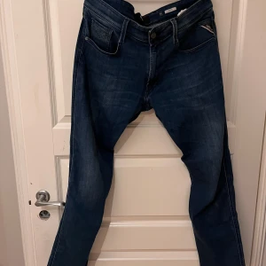 Blå jeans från Replay - Snygga medium blå jeans från Replay, modell Anbass. De har en klassisk femficksdesign och en bekväm passform. Perfekta för en avslappnad stil. Strl w 34 L 32