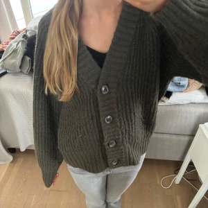 Olivgrön stickad kofta  - Mysig olivgrön stickad kofta från Gina Tricot med knappar framtill. Perfekt för kyligare dagar med sin ribbade struktur och långa ärmar, strl xs💖