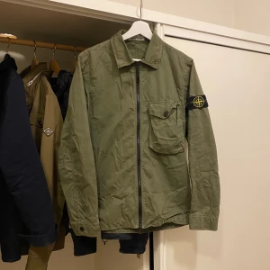 Grön jacka från Stone Island - Säljer en fet jacka från Stone Island, perfekt för våren och sommaren! Storlek S, hör av dig vid frågor.