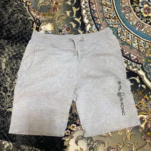 Grå shorts från Sail Racing - Snygga grå shorts från Sail Racing med snörning i midjan och en stilren logga på benet. Perfekta för en avslappnad stil. De har en bekväm passform och är tillverkade i ett bra material.
