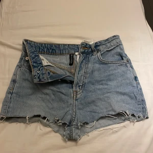Blåa avklippta jeansshorts  - Blåa avklippta jeansshorts från H&M Divided med fransiga kanter och knappar🩷