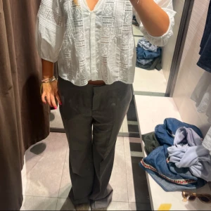 Grå kostymbyxor - Snygga grå kostymbyxor med en klassisk straight passform. Perfekta för en stilren look. Byxorna har en hög midja och är tillverkade i ett bekvämt material som ger en elegant siluett.