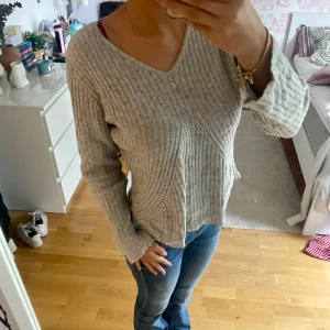 Grå ribbad tröja - Säljer en grå ribbad tröja med v-ringning och bekväm stretchig passform. 