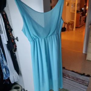 Ljusblå klänning - Liten skada. Se bild. Därav priset 