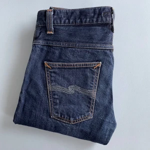 Mörkblå selvedge jeans från Nudie Jeans - Snygga mörkblå jeans från trendiga märket Nudie Jeans i selvage raw denim. Populära modellen Grim Tim 🙌 Använda med sköna fades som tillkommer när man använder jeansen. Storlek 30/30. Missa inte dessa jeans! Hör gärna av er vid frågor /Ebbe 🤩🤩