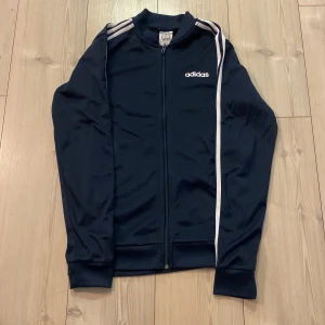 Adidas kofta - Storlek XS Adidas kofta med dragkedja. Den är i bra skick och säljs för att den är för liten för mig. Den har fickor på varsin sida .