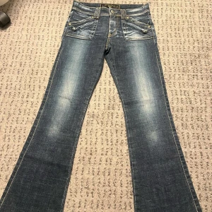 2000s jeans - Säljer dessa sjukt fina jeans med detaljer på både baksidan och framsidan. Dessa jeans har inga besvär, de är som helt nya jeans från 2000-talet 💞 Orginal priset är runt 1 300kr! midja: 26 lår: 22cm innerben: 72 cm 