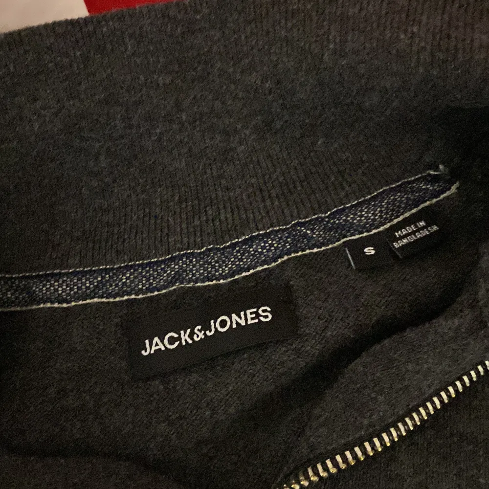 Säljer en snygg mörkgrå tröja från Jack & Jones i storlek S. Den har en praktisk dragkedja vid halsen och är perfekt för både höst och vinter. Tröjan är långärmad och gjord i ett mjukt material som håller dig varm och bekväm. Passar både till vardags och lite mer avslappnade tillfällen. inga defekter använd 2 gånger kanske 3 inga defekter kicka gärna på . Tröjor & Koftor.