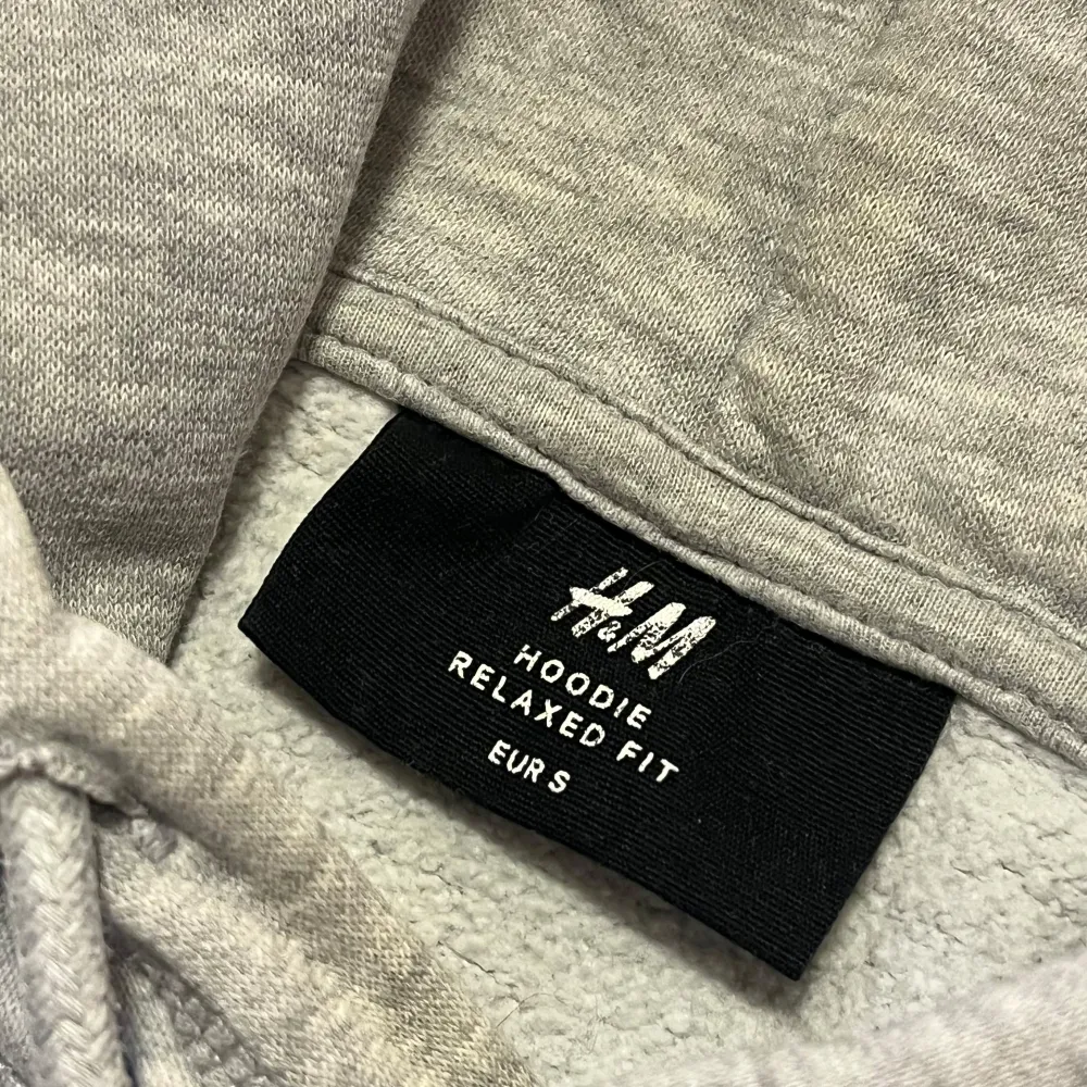 Grå hoodie från H&M i storlek S. Den har en avslappnad. Hoodien har en klassisk ficka och justerbar huva. Använd ett par gånger, inga skador alls.. Hoodies.