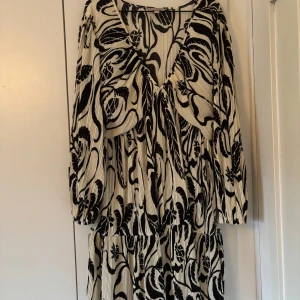Svartvit mönstrad klänning från H&M - Säljer en svartvit klänning från H&M i storlek L. Stor i bysten men annars bra i storleken. 