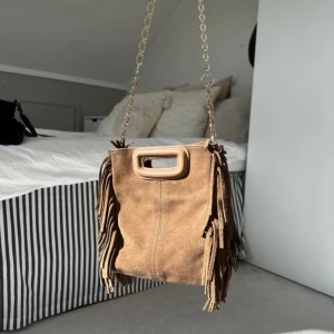 Brun mocka axelväska med fransar - Säljer min superfina bruna maje väska i mocka. Väskan är i bra skick och inte används så mycket, har kvar påse osv. 