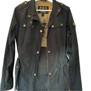 Marinblå jacka från Barbour International - Säljer en snygg marinblå jacka från Barbour International i storlek M. Jackan har en snygg design med guldknappar och dragkedja. Perfekt för höst och vår, med långärmad stil och flera praktiska fickor. Passar både till vardags och lite mer uppklädda tillfällen. Nypris 2499:- pris kan diskuteras 💞jag står för frakt