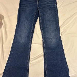 Blå jeans från Gina Tricot - Säljer ett par snygga blå jeans från Gina Young i storlek 164, lite stora i storleken. De har en bootcut. Jeansen är i mycket bra skick och har en bekväm passform. Perfekta för höst och vår! 