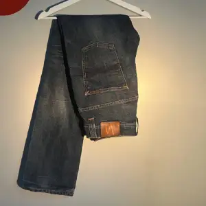 Säljer ett par snygga mörkblå jeans från Nudie Jeans i storlek 34/34. Men passar som 32/32