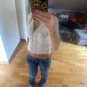 Vit stickad bolerotopp - Säljer en söt vit stickad trekvartsärmad kofta med knappar framtill. Den är kortärmad och har en fin, luftig stickning som passar perfekt för många årstider. Knappt använd 