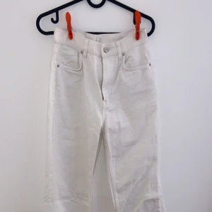 Vita jeansbyxor - Säljer ett par vita jeansbyxor i bra skick. De har en klassisk femficksdesign och är perfekta för både vardag och fest. Byxorna har en rak passform och är tillverkade i ett slitstarkt material. Perfekta för vår och sommar!