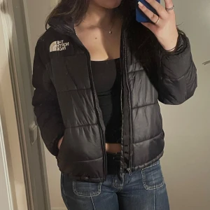 Svart pufferjacka från The North Face - Säljer en snygg svart pufferjacka från The North Face i storlek L. Jag är 175 som referens. Använd men i mycket bra skick. Passar perfekt för höst och vinter! Är öppen för frågor och prisförslag!💕