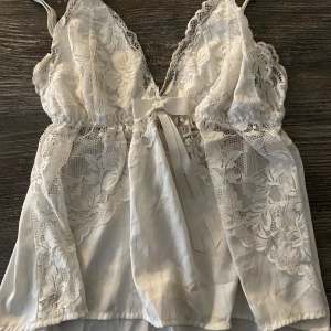 Vit spetslinne med rosett - Säljer ett superfint vitt nattlinne med spetsdetaljer och rosett som man också kan ha på sig vid andra tillfällen och styla på olika sätt💕 strlk S men passar också XS