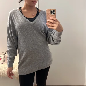 Grå tröja i ullblandning - Säljer en supermysig grå tröja i ullblandning. Den har en v-ringad design och långa ärmar, perfekt för kyliga dagar. Tröjan är i bra skick och passar både till vardags och lite finare tillfällen. Perfekt för höst och vinter! Passar XS - L