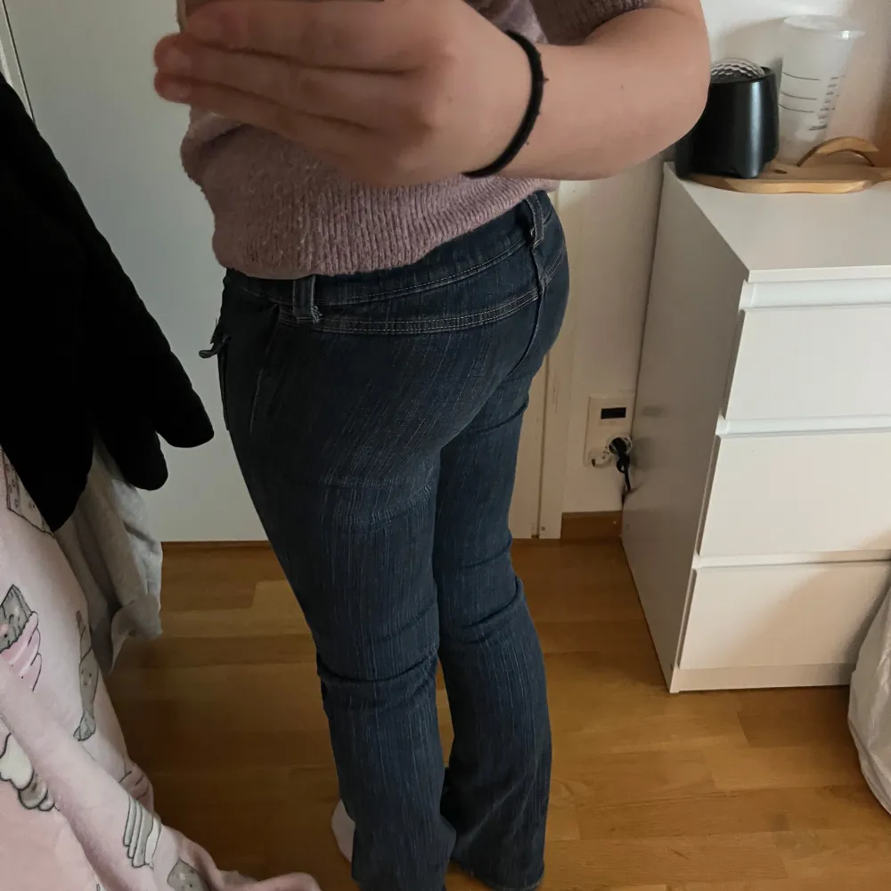 Säljer ett par snygga blå bootcut jeans från H&M i storlek EUR 158. De har låg midja och justerbar midja för perfekt passform. Perfekta för en avslappnad stil med en touch av retro. Använda men i bra skick!. Jeans & Byxor.