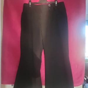 Svarta byxor med vida ben - Säljer ett par svarta byxor med vida ben och hög midja. De har en stilren design med knappar i midjan. 