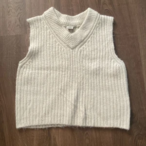 Vit ribbad stickad väst från SRN HLT - Säljer en superfin vit stickad väst från SRN HLT. Den är ribbad och har en snygg v-ringad design. Perfekt för lager-på-lager under höst och vinter. Västen är i mycket bra skick och passar till både vardag och fest. 🧶✨146-152 använd 1 gång 