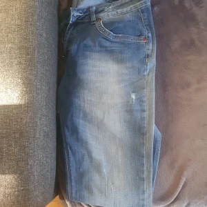 Perfekt Jeans -Blå jeans i bra skick - Säljer ett par snygga blå jeans i bra skick. De har en klassisk femficksdesign och en bekväm passform. Perfekta för vardagsbruk och kan enkelt matchas med olika outfits. Passar både till skola och fritid.