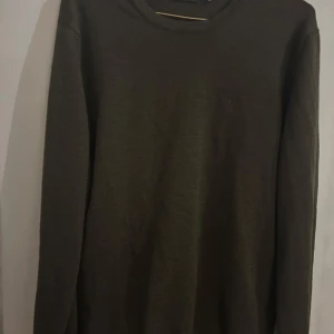 Mörkgrön tröja från J.Lindeberg - Säljer en stilren mörkgrön tröja från J.Lindeberg i storlek M. Tröjan är långärmad och perfekt för både höst och vinter. Den är i mycket bra skick och passar bra till både vardag och fest. En klassisk och tidlös design som är lätt att matcha med andra plagg.