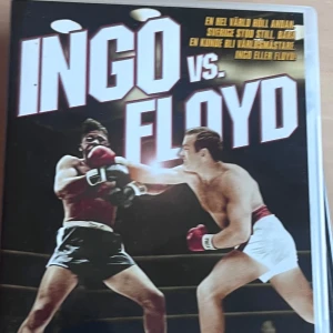 Ingo vs. Floyd - Boken 'Ingo vs. Floyd' handlar om den legendariska boxningsmatchen mellan Ingemar Johansson och Floyd Patterson. Omslaget visar en dramatisk scen från ringen med båda boxarna i aktion. Perfekt för den som älskar sporthistoria och spänning!