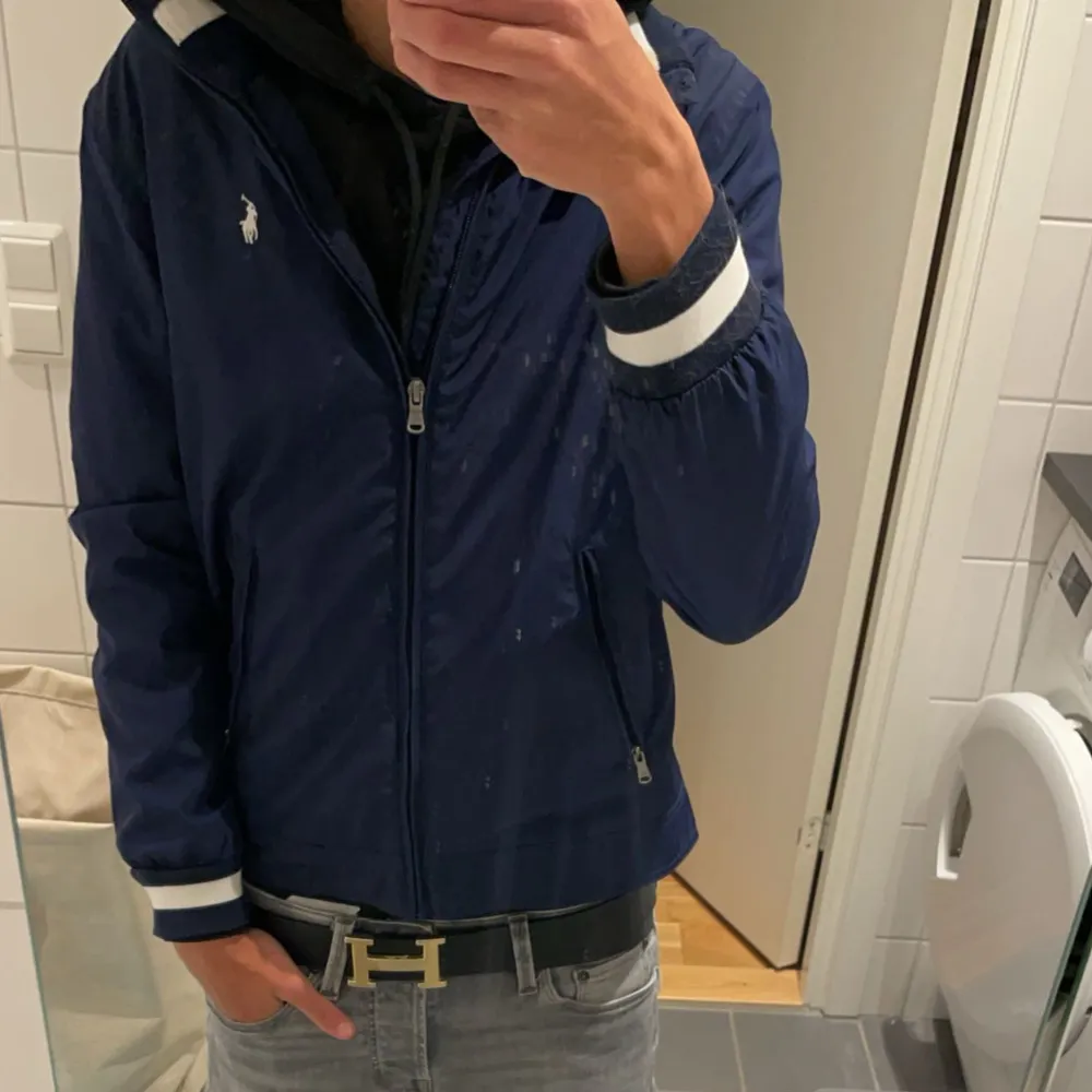 Säljer en snygg mörkblå jacka från Polo Ralph Lauren. Den har en dragkedja framtill och två fickor med dragkedjor. Perfekt för höst och vår. Jackan är i mycket bra skick och passar till både vardag och fest.. Jackor.