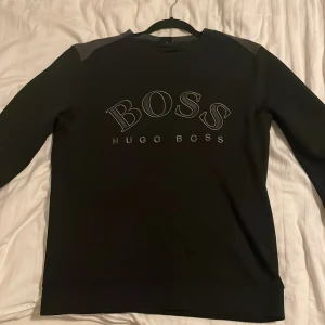 Svart Hugo Boss tröja - Säljer denna hugo boss tröja då den ej kommer till användning. Inga skador eller defekter den är som ny. Pris 800kr.