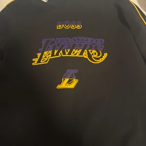 Svart hoodie från Boss x Los Angeles Lakers - Fin Hugo Boss X Lakers, Knappt använd köpte för 2200kr. Perfekt skick