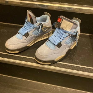 Jordan 4 university blue  - Säljer ett par Jordan 4s university blue använda fåtals gånger och mycket bra skick.                                                   Storlek 43 passar även 42 1/2och creaseskydd medföljer (pris kan sänkas vid snabb affär).                         Skorna ser lite bleka ut på bilderna kontakta mig för andra bilder!
