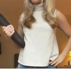 Beige zara topp - Säljer en stilren beige ärmlös polotopp i mjukt material. Perfekt för lager-på-lager eller att bära som den är under varmare dagar. Toppen har en hög krage som ger en elegant touch. Passar både till vardags och festliga tillfällen.