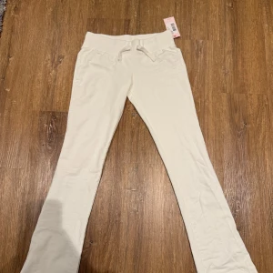 Vita Cozy Chill Pants från Nelly - Superbekväma vita mjukisbyxor från Nelly i modellen Cozy Chill Pants. De har en låg midja och en skön passform med snörning i midjan. Byxorna är helt nya och oanvända med prislapp!