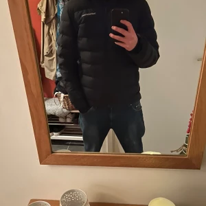 Svart pufferjacka från Peak Performance - Säljer en svart pufferjacka från Peak Performance i mycket bra skick. Jackan är perfekt för kalla dagar med sin quiltade design och långa ärmar. Den har en dragkedja framtill och är riktigt skön och varm. Passar perfekt för både höst och vinter. Storlek herr M. Nypris=4900kr