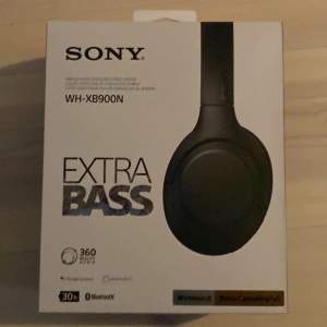 Säljer ett par Sony WH-XB900N hörlurar med Extra Bass för en kraftfull ljudupplevelse. De är trådlösa och har Bluetooth-anslutning, samt stöd för 360 Reality Audio. Hörlurarna är svarta och kommer i originalförpackning. Perfekta för musikälskare som vill ha djup bas och klar röståtergivning.