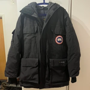 Svart Canada Goose jacka  - Säljer nu min Canada goose jacka då jag köpt en ny den är i ganska bra skick förutom på armen som man ser på bilden men har en extra som man kan byta