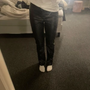 Svarta skinnbyxor från Missguided - Säljer ett par snygga svarta skinnbyxor från Missguided i storlek EU 36. De är tighta och har en hög midja och slits längst ner på byxan🤍