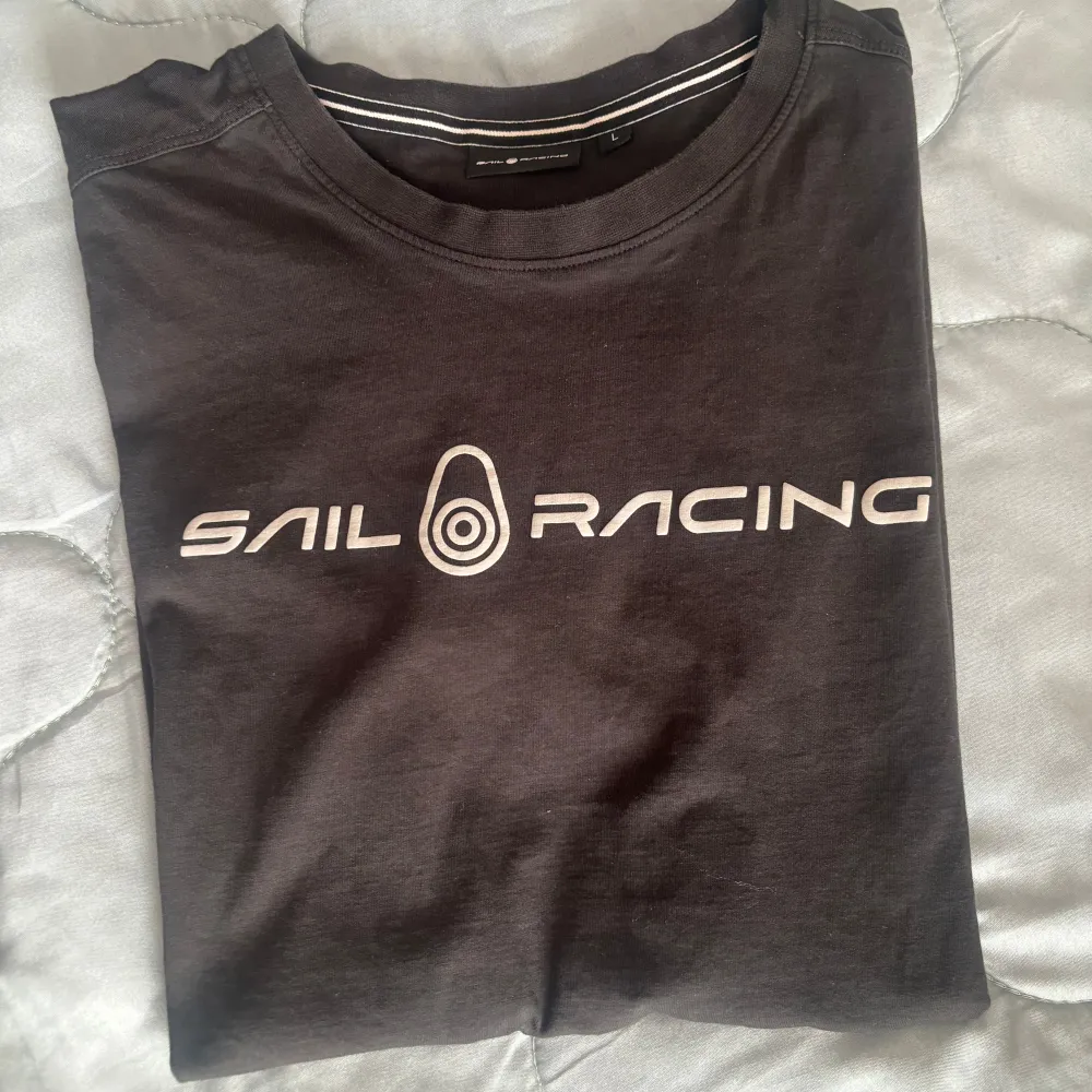 Säljer en svart t-shirt från Sail Racing i bra skick. Passar bra till jeans eller shorts!. T-shirts.