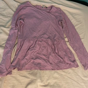 Rosa tröja. Utsvängd  - En rosa tröja. Är som en klänning fast som tröja. Är stretchig. Storlek 158/164.