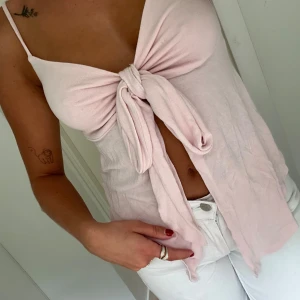 Ljusrosa knytlinne - Säljer ett supergulligt ljusrosa linne med knytning framtill. Aldrig använd!❣️