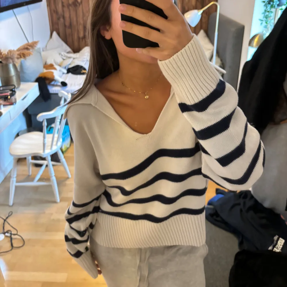 Säljer en supermysig vit tröja med blå ränder. Den har en avslappnad passform och är perfekt för både chill dagar hemma och när du vill vara bekväm men ändå snygg. Tröjan är långärmad och har en v-ringad hals, vilket ger den en lite mer stilren look. Perfekt för höst och vår! Tröjan är i en Xl, men passar mig som vanligtvis är en S/m. Neuletakit & Villapaidat.