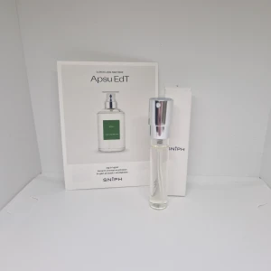 Apsu EdT från Ulrich Lang New York - Säljer en elegant och fräsch Apsu EdT från Ulrich Lang New York. Flaskan är stilren och genomskinlig med en silverfärgad spraykork. Parfymen kommer i en vit kartong med minimalistisk design. Perfekt för dig som gillar en modern och ren doft. Köp nu och upplev en touch av lyx! 💚