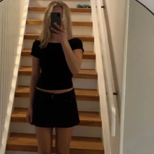 Svart lågmidjad jeanskjol - Super snygg svart lågmidjad jeanskjol köpt second hand i Spanien!! Jätte cool med bälte och strumpbyxor nu till hösten eller ha till en snygg tröja på sensommaren   Obs såld!!!