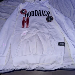 Vit hoodie från Hoodrich - Säljer en snygg vit hoodie från Hoodrich i storlek XS. Den har coola detaljer som broderade märken och en stor ficka framtill. Perfekt för en avslappnad stil! har färg på sig som du kan se på bild 5🖤
