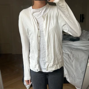 Kofta  - Vit kofta i jättebra skick. Superfina knappar som skimrar till i en pärlemorsfärg i ljuset💗 lappen är tyvärr bortklippt så ser inte var den kommer ifrån men jag köpte den för några år sedan i London!