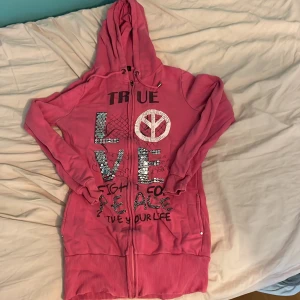 Rosa tjocktröja med text - En rosa tjocktröja med text och är lång. Storlek 146/152.